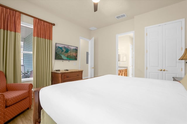 bedroom with ceiling fan, light hardwood / wood-style flooring, a closet, and ensuite bathroom