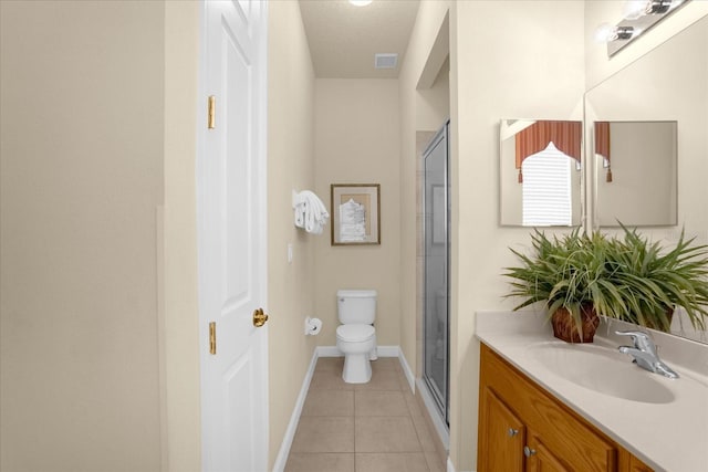 bathroom with tile patterned floors, toilet, vanity, and a shower with shower door