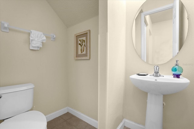 bathroom featuring tile patterned flooring, toilet, and vaulted ceiling