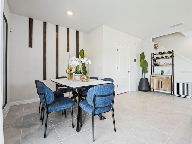 dining space featuring light tile patterned floors, visible vents, and arched walkways