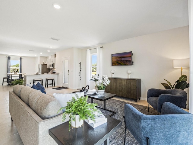 living area featuring recessed lighting, visible vents, and baseboards