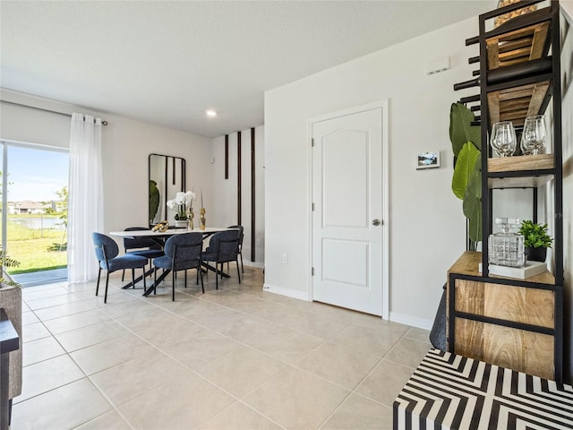 dining space with light tile patterned floors and baseboards