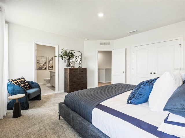 bedroom featuring light carpet, a closet, visible vents, and ensuite bathroom