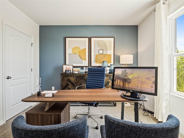 carpeted office with a healthy amount of sunlight and baseboards