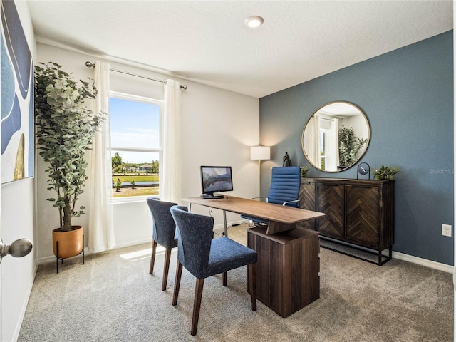 office area with a textured ceiling, light colored carpet, and baseboards