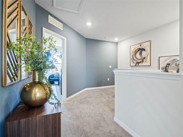 corridor with carpet floors, baseboards, and visible vents