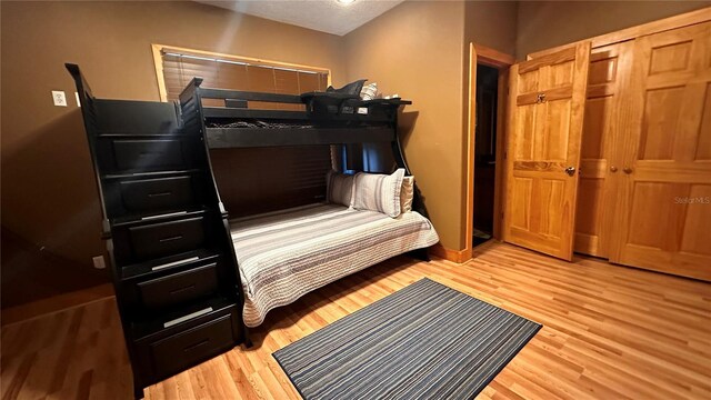 bedroom with light hardwood / wood-style flooring and a closet