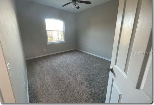 unfurnished room with dark colored carpet and ceiling fan