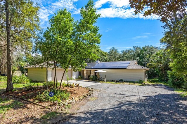 ranch-style house featuring solar panels and a garage