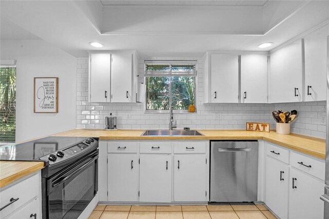 kitchen featuring stainless steel dishwasher, black range with electric stovetop, sink, and white cabinetry