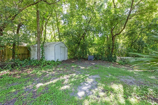 view of yard with an outbuilding, fence, and a storage unit