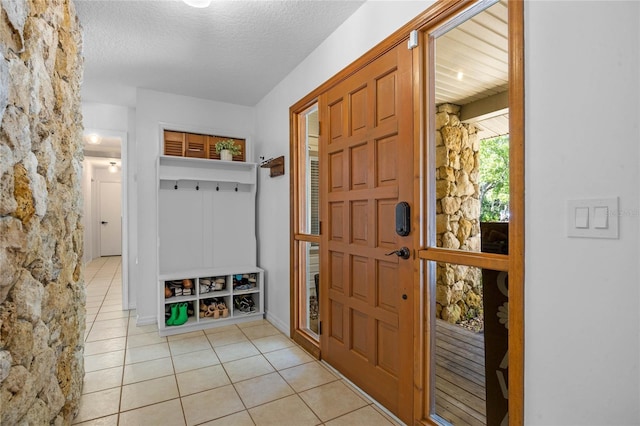 mudroom featuring light tile patterned floors and a textured ceiling