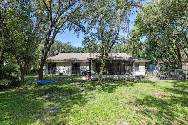 back of house featuring a yard, fence, and a sunroom