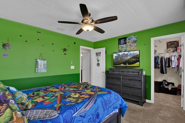 carpeted bedroom with a textured ceiling, a closet, and ceiling fan