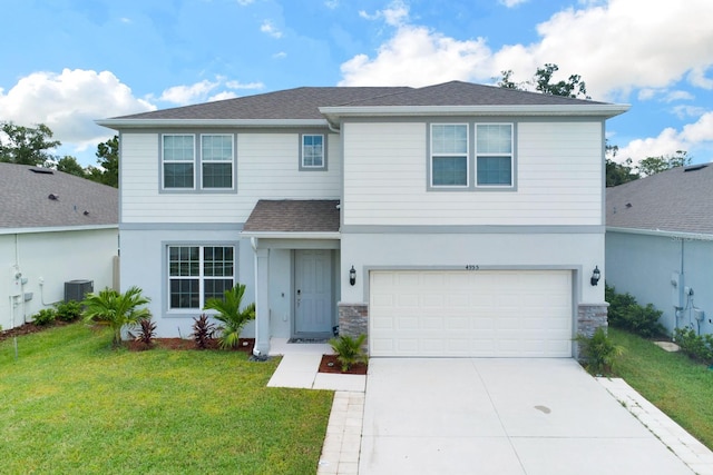 view of front property featuring a garage, a front yard, and central AC