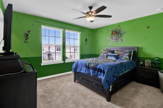 bedroom with ceiling fan, light carpet, and a textured ceiling