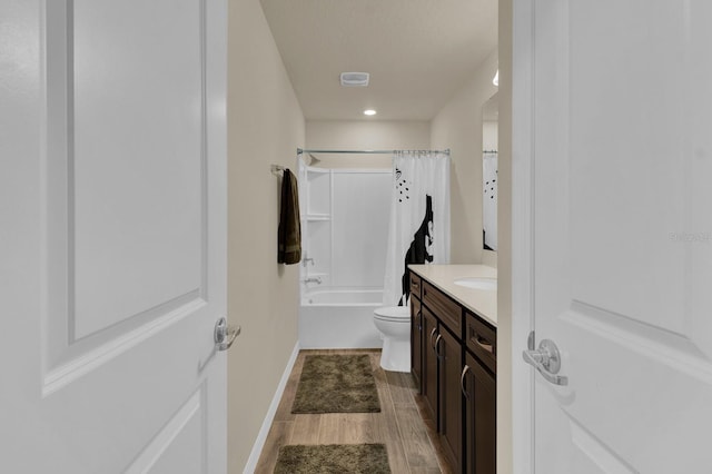 full bathroom with wood-type flooring, vanity, shower / tub combo, and toilet