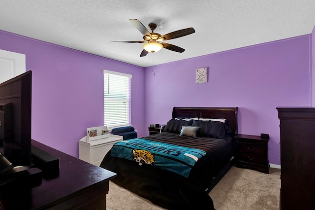 carpeted bedroom featuring ceiling fan and a textured ceiling