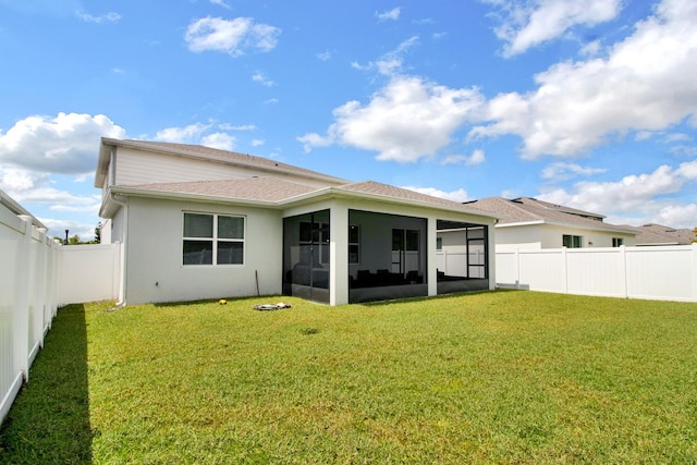 back of property with a lawn and a sunroom