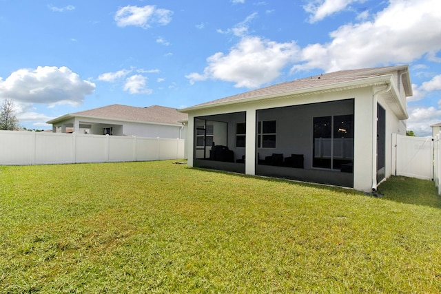 back of property with a lawn and a sunroom