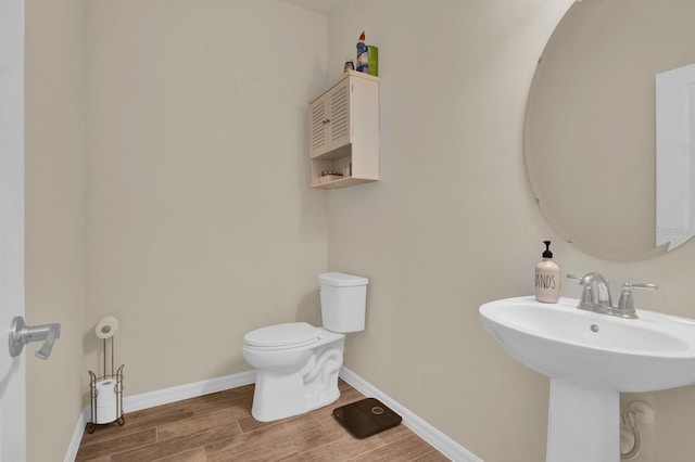 bathroom with hardwood / wood-style flooring, toilet, and sink