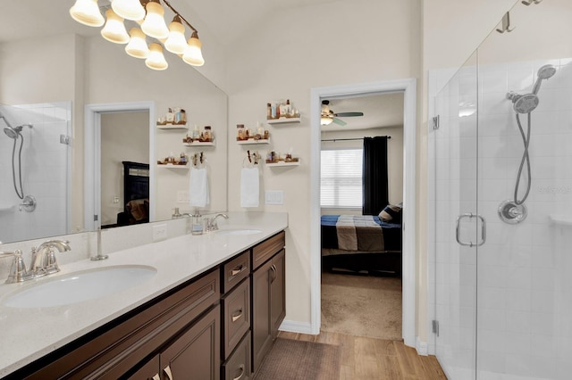 bathroom with ceiling fan, walk in shower, hardwood / wood-style floors, vaulted ceiling, and vanity