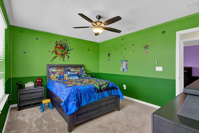 bedroom with ceiling fan, light colored carpet, and a textured ceiling