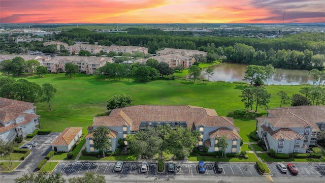 aerial view at dusk featuring a water view