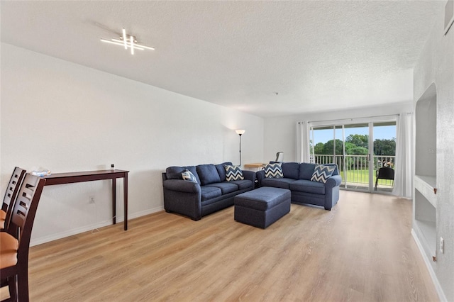 living room with light wood-type flooring and a textured ceiling