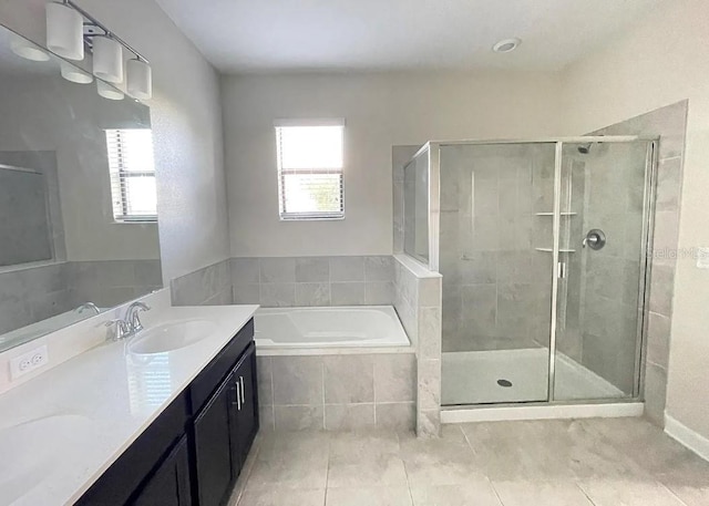 bathroom with tile patterned floors, independent shower and bath, and vanity