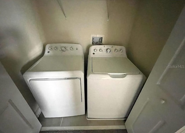 laundry room featuring tile patterned floors and separate washer and dryer