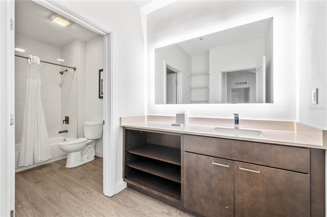 full bathroom with hardwood / wood-style floors, shower / bath combination with curtain, toilet, and vanity