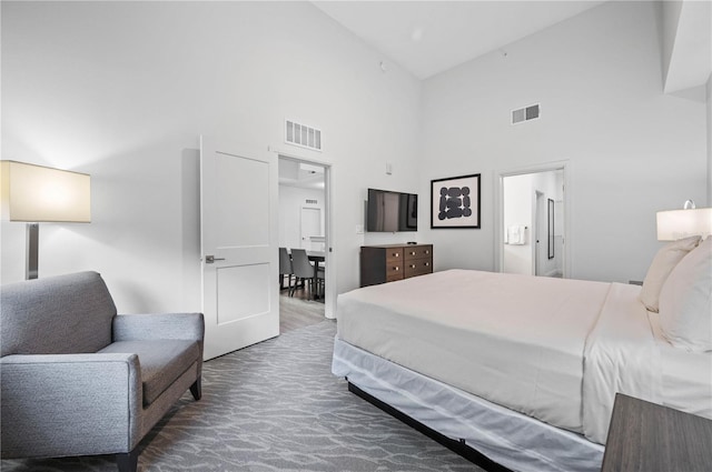 carpeted bedroom featuring high vaulted ceiling and connected bathroom