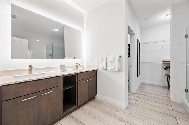 bathroom featuring walk in shower and vanity