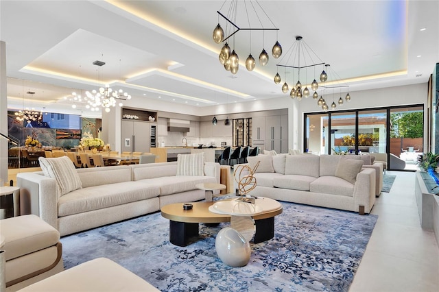 living room with a tray ceiling and an inviting chandelier