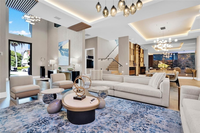 living room featuring a towering ceiling, a raised ceiling, and a notable chandelier