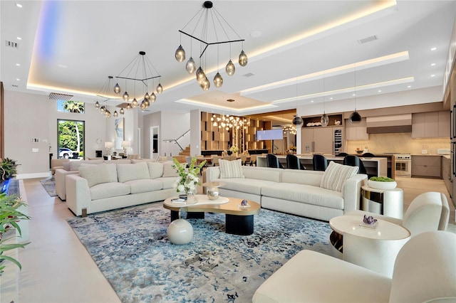 living room featuring an inviting chandelier and a raised ceiling