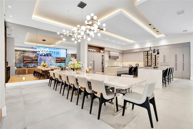 dining room with a raised ceiling and an inviting chandelier