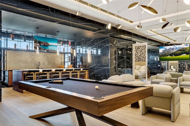 playroom featuring bar area, a raised ceiling, and billiards