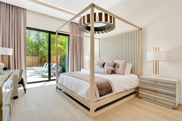 bedroom with hardwood / wood-style floors and access to outside