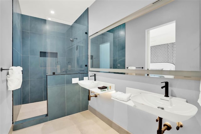 bathroom with a tile shower and sink