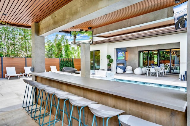 view of patio / terrace featuring exterior bar and a fenced in pool