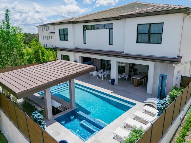 back of property with a patio area and a swimming pool with hot tub