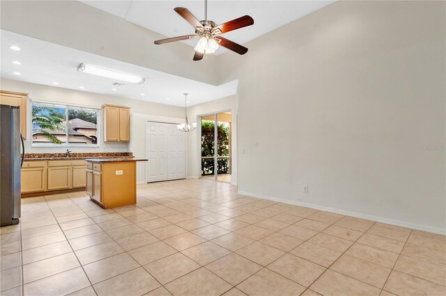 kitchen featuring light brown cabinets, light tile patterned floors, and stainless steel fridge