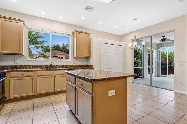 kitchen featuring plenty of natural light, light brown cabinetry, light tile patterned floors, and a center island