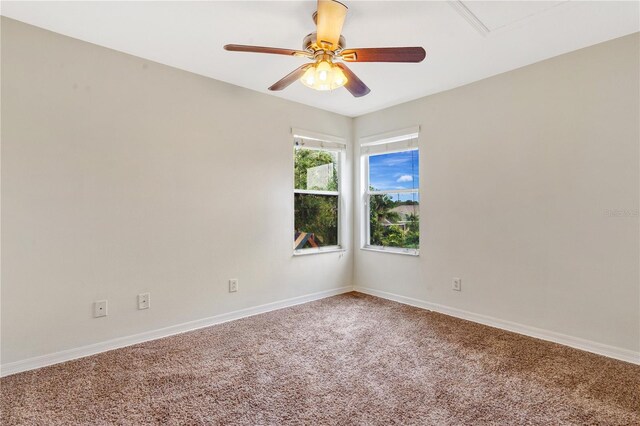 carpeted spare room featuring ceiling fan