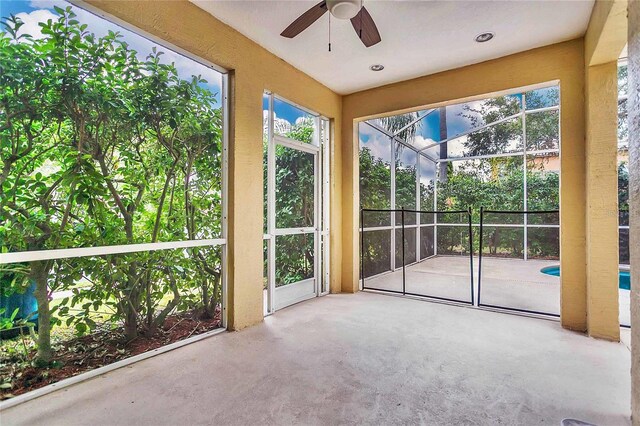 unfurnished sunroom with ceiling fan