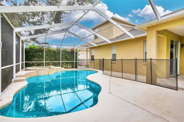 view of swimming pool featuring a lanai, an in ground hot tub, and a patio area