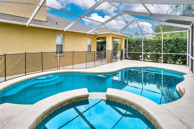 view of pool featuring glass enclosure and an in ground hot tub