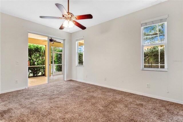 empty room with ceiling fan, a healthy amount of sunlight, and carpet floors